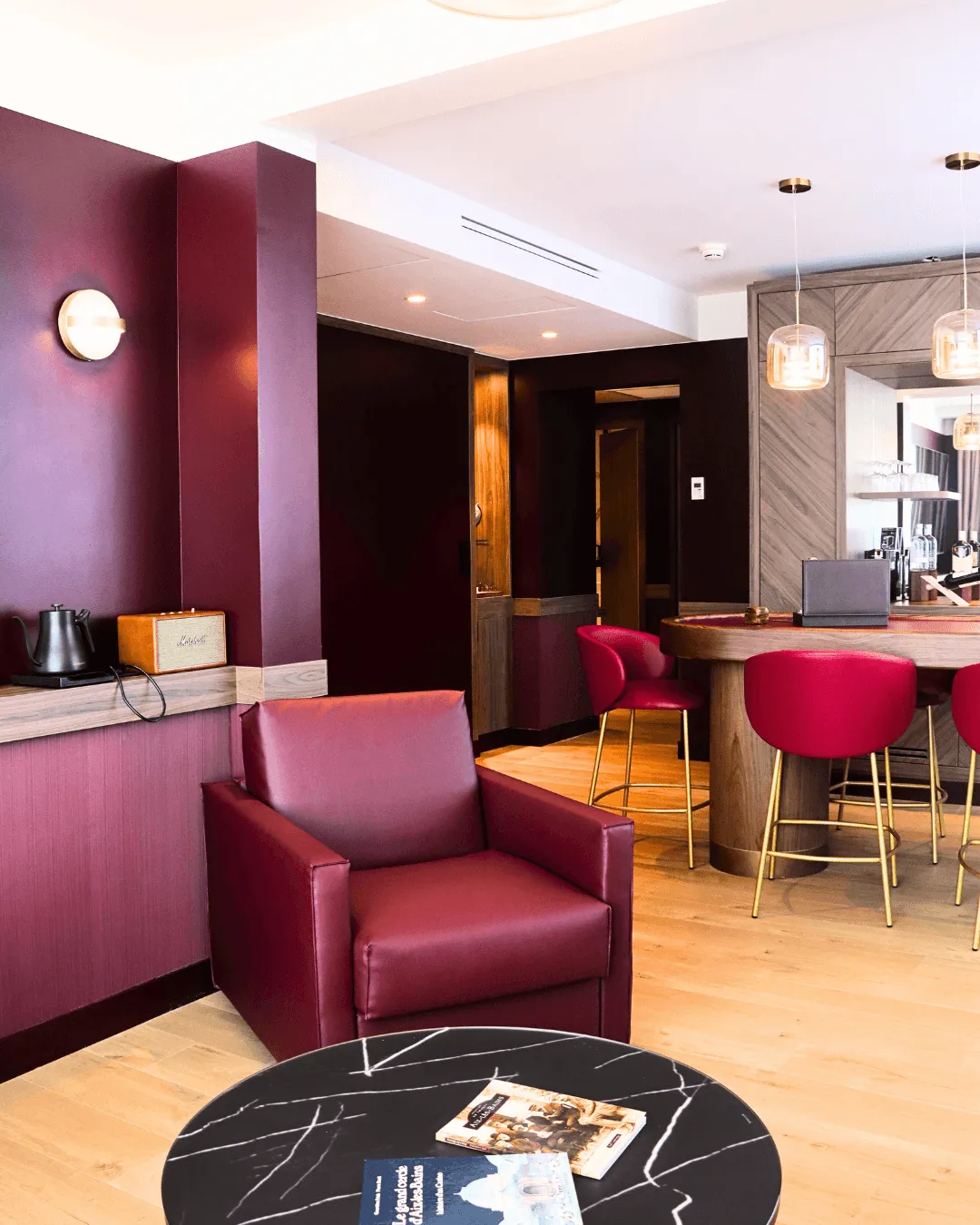 Ein modernes Wohnzimmer mit braunen Ledersitzen, einem schwarzen Marmortisch und einer Bar mit passenden Hockern