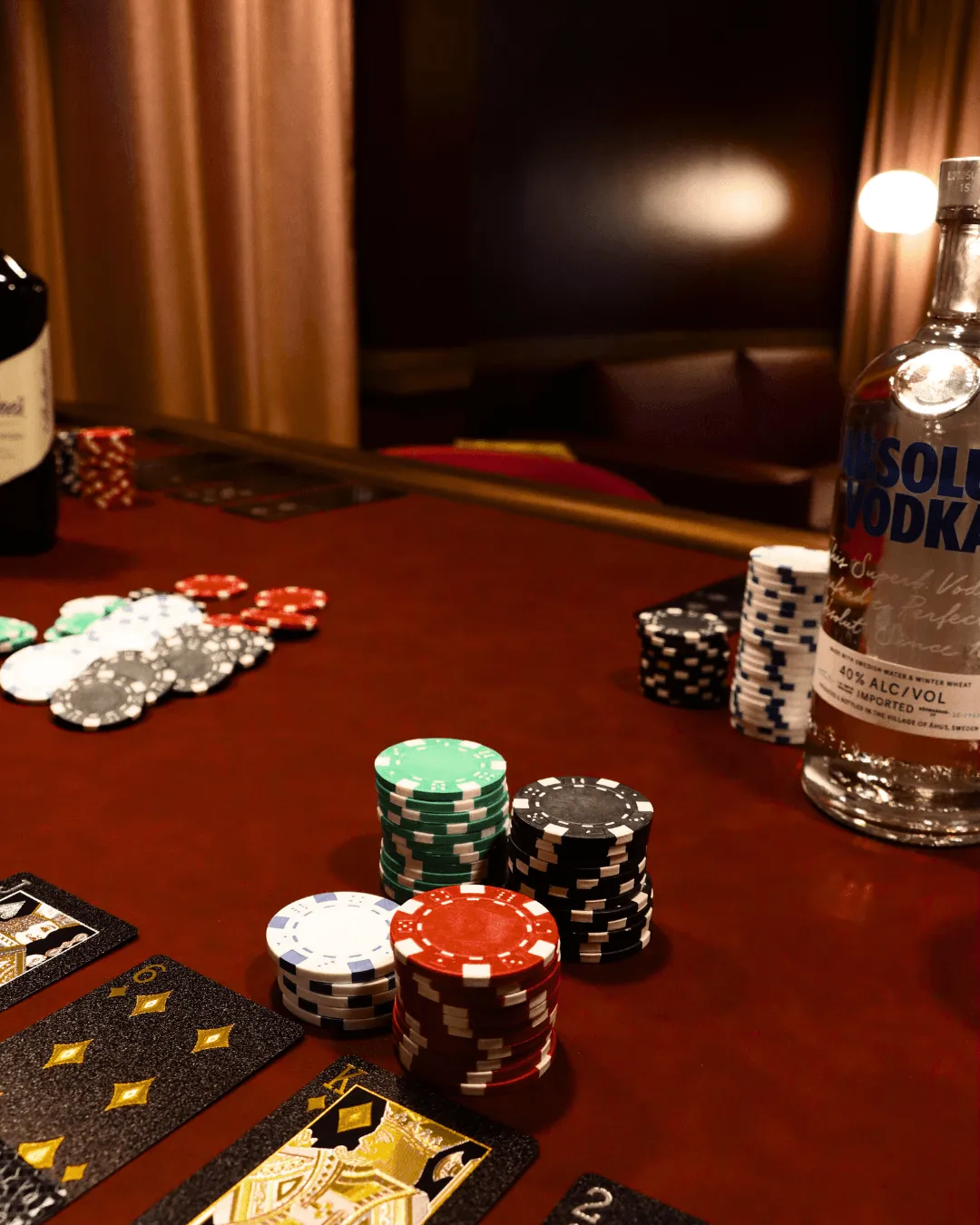 Poker-Tisch mit Jetons, Karten und Alkoholflaschen